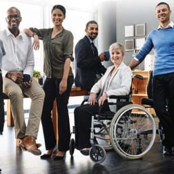 group of racially and gender diverse office workers smiling for camera