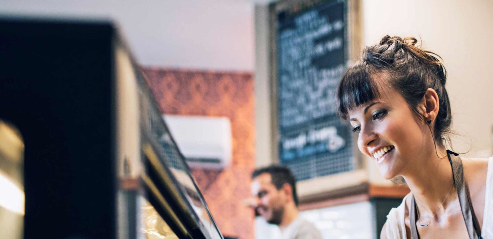 smiling coffee shop employee looking downwards