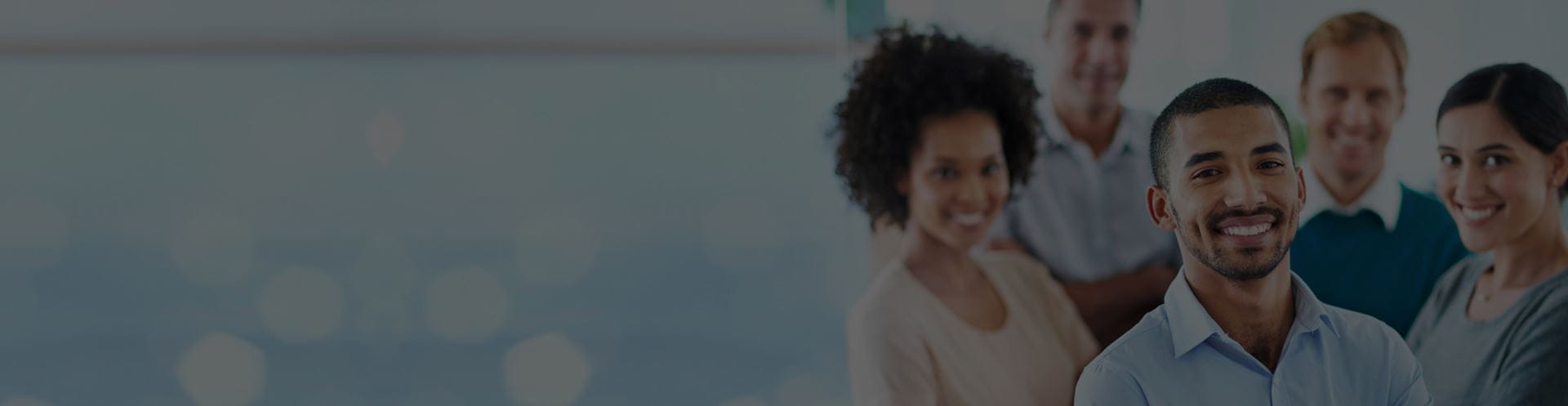 group of smiling employees posed together in a cluster